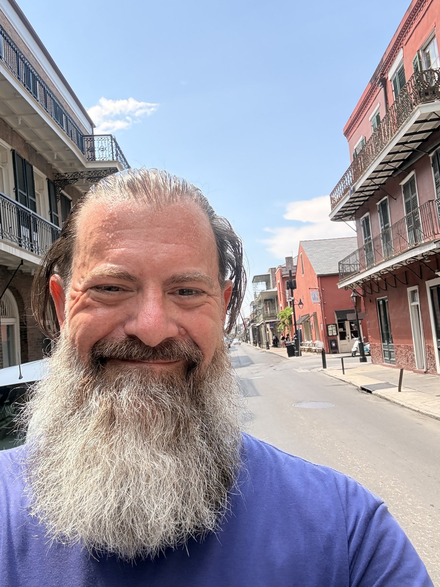 Loren Weisman smiling on a French Quarter street in New Orleans on a clear day