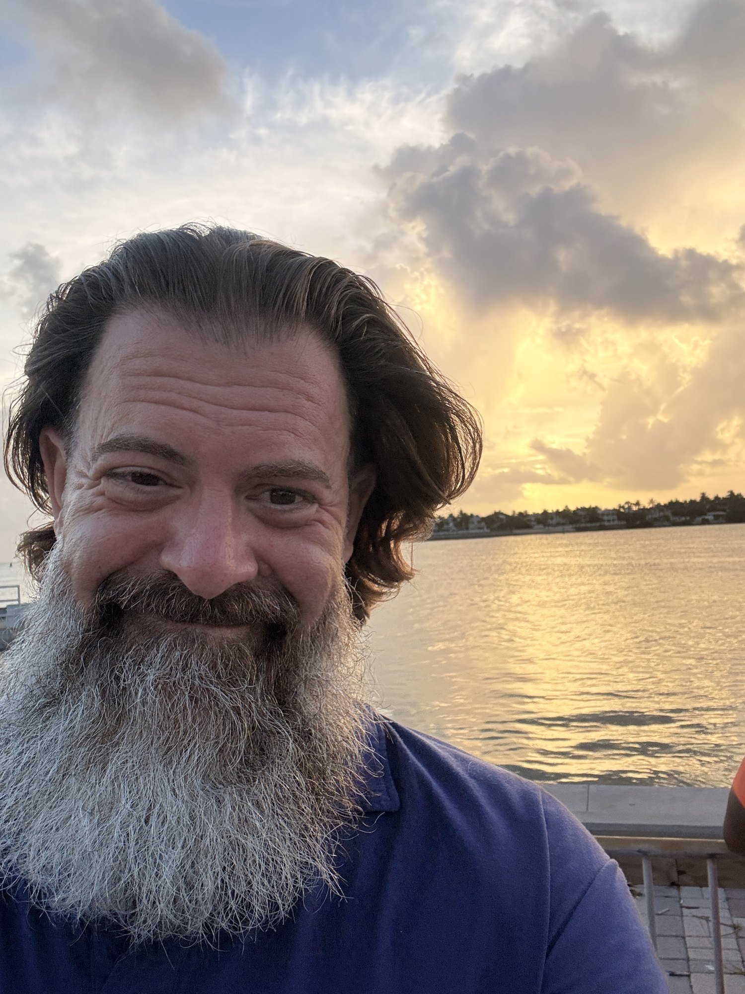Loren Weisman, host of the Wait What Really OK podcast, photographed at sunset beside the water